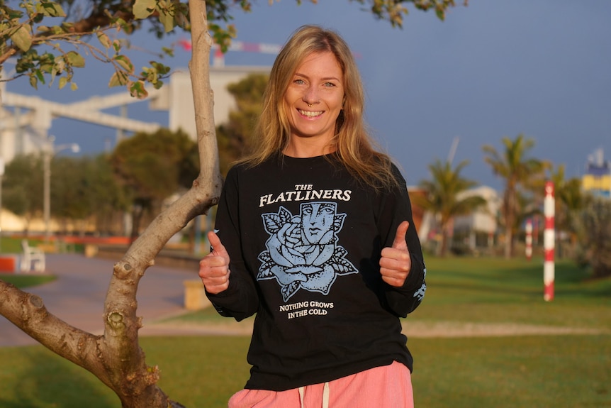Jaz McCarntey smiles at the camera and puts both thumbs up