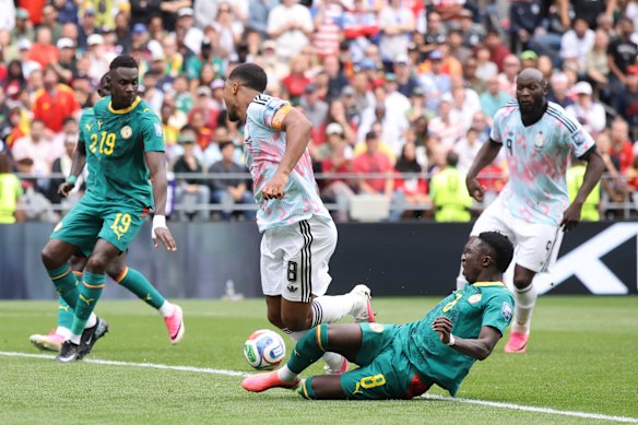 Youri Tielemans of Belgium is tackled by Lamine Camara of Senegal in the penalty box, which goes to the VAR review.