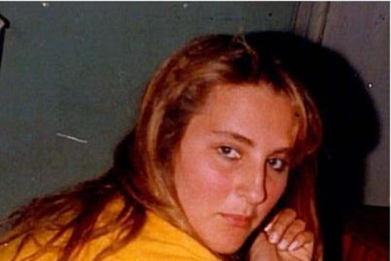 A close-up of a teenage girl looking at the camera over her shoulder.