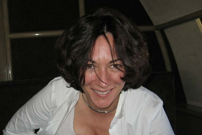 Ghislaine Maxwell in a white shirt, grinning at the camera