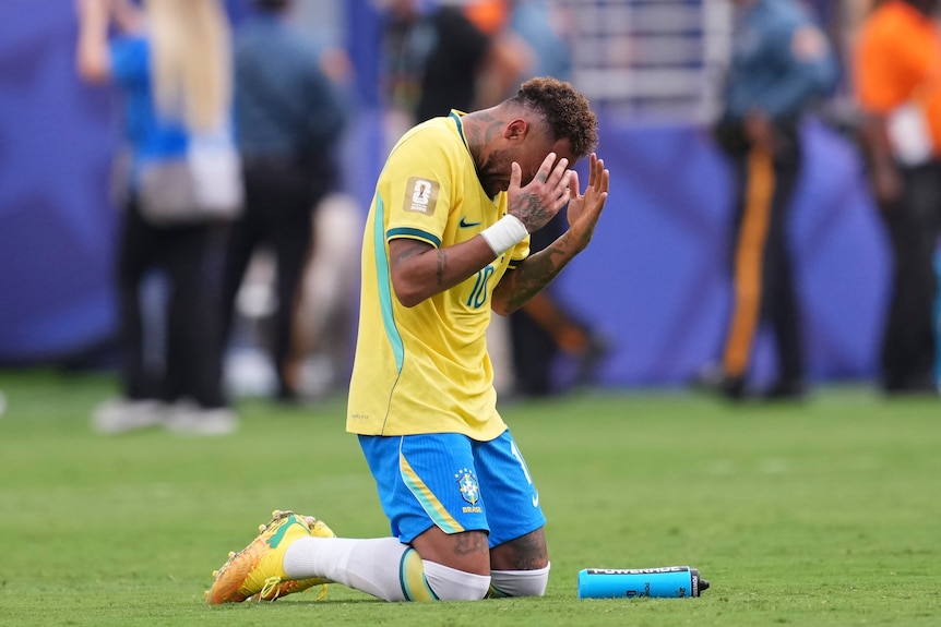 Neymar prays on his knees after his last Brazil game
