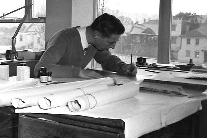 A black and white photograpgher of a cartographer at a drafting desk