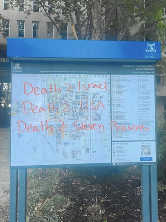 A noticeboard that says "University of Melbourne" is graffitied with words including a death threat.