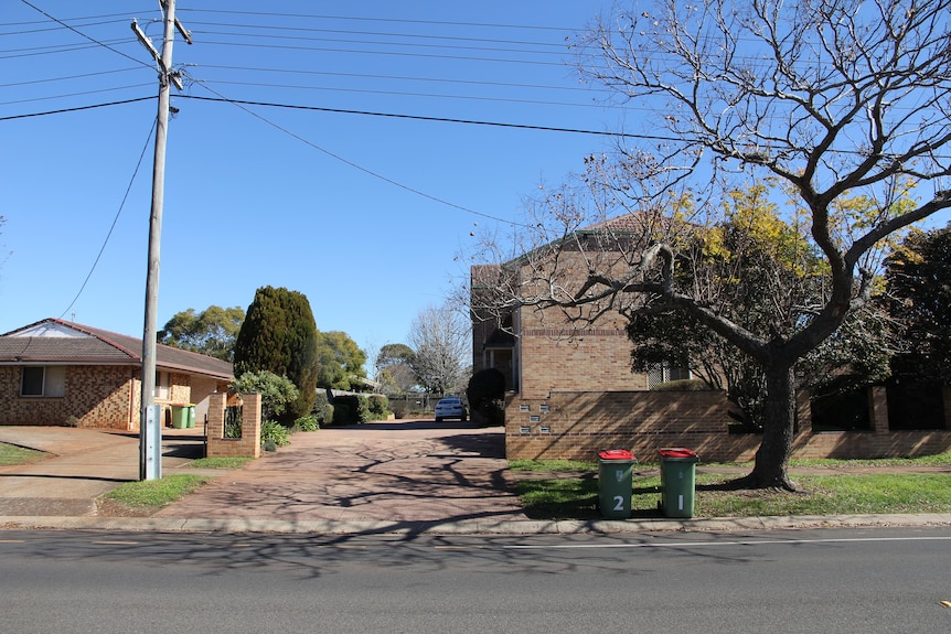 A brick unit block on a suburban street.
