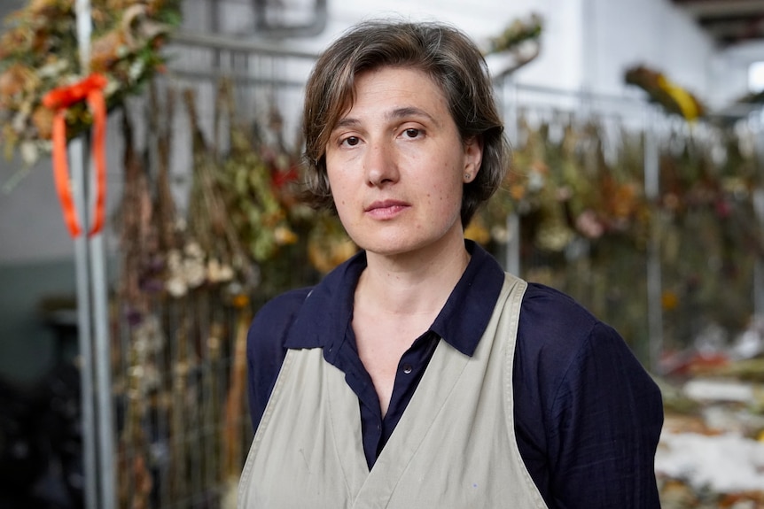 A woman with short, dark hair in a large storage space.
