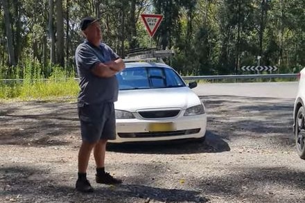 Steve Preston standing with arms crossed in front of a white car.