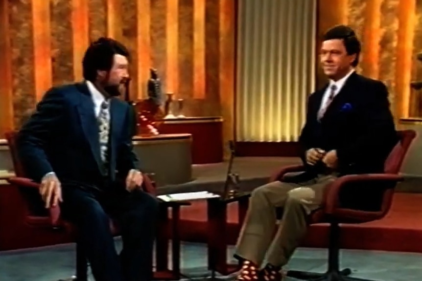 Derryn Hinch seated in a television studio with Ray Martin in the 1990s.
