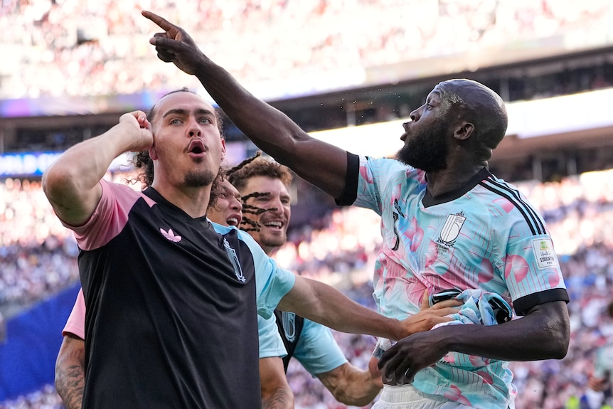 Belgian players celebrate and gesture towards the crowd after scoring a goal