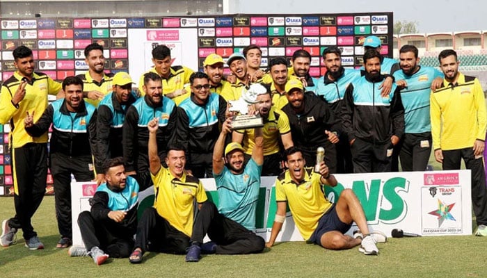 Peshawar players and support staff celebrate with the trophy after winning the Pakistan Cup by defeating Karachi Whites in the final at the Rawalpindi Cricket Stadium in Rawalpindi on November 19, 2023. — PCB