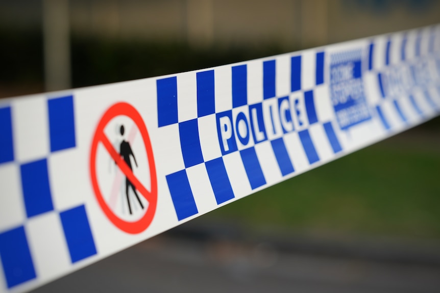 Images of blue and white checkered police tape stretched across a suburban street.