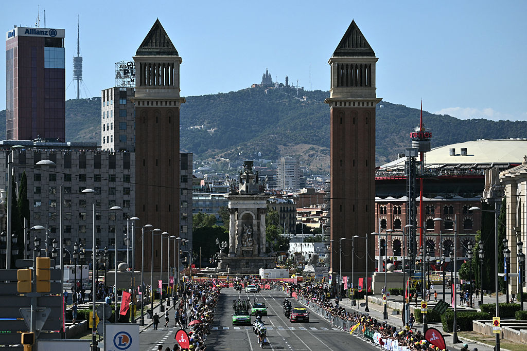 The team Caja Rural-Seguros RGA cycles next to the Venetian Towers at the Pla&ccedil;a d'Espanya during the 1st stage of the 113th edition of the Tour de France cycling race, a 19,6 km team time trial stage in and around Barcelona in northeastern Spain, on July 4, 2026. (Photo by Jeff PACHOUD / AFP)