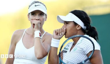 Katie Boulter and Heather Watson discuss tactics during their doubles match at Wimbledon