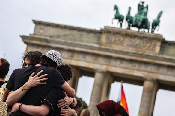 Mourners embrace at a makeshift memorial at Pariser Platz, in front of the Brandenburg Gate.
