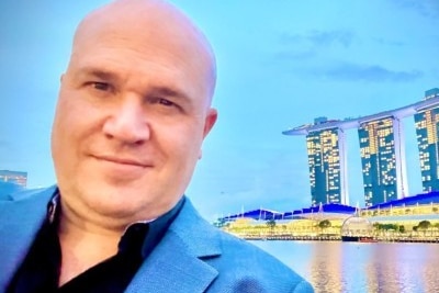A bald man wearing a light blue suit.