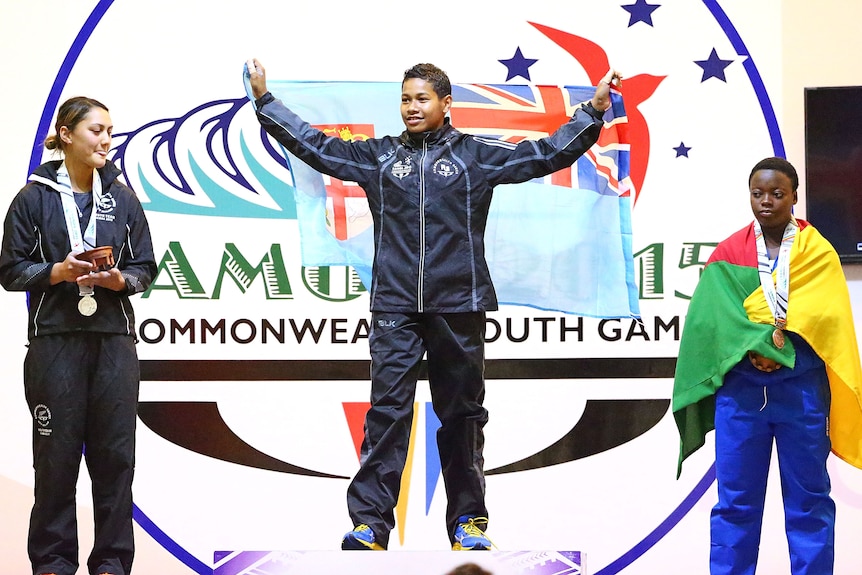 Three young women on a podium.