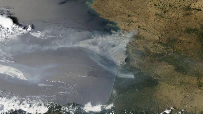 Layered satellite images show a cloud of smoke over southwest France on Monday.