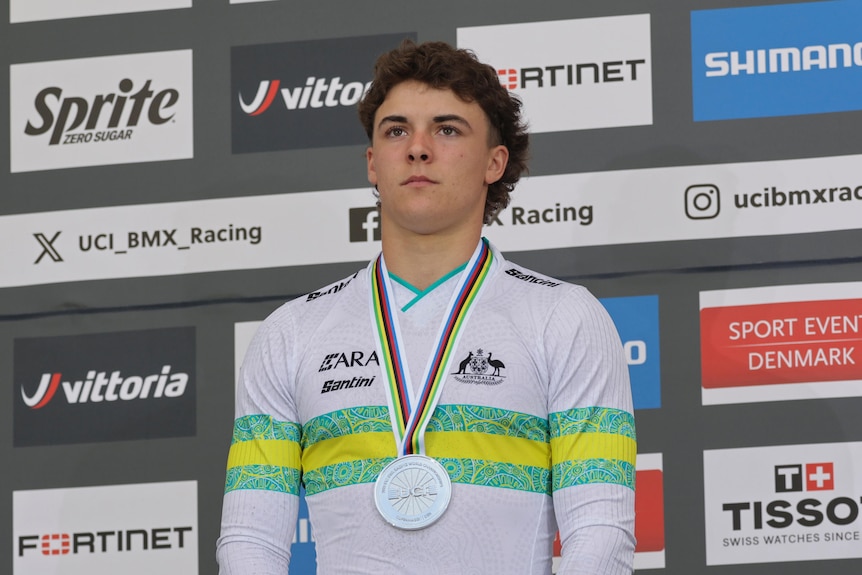 Josh Jolly stands with a silver medal
