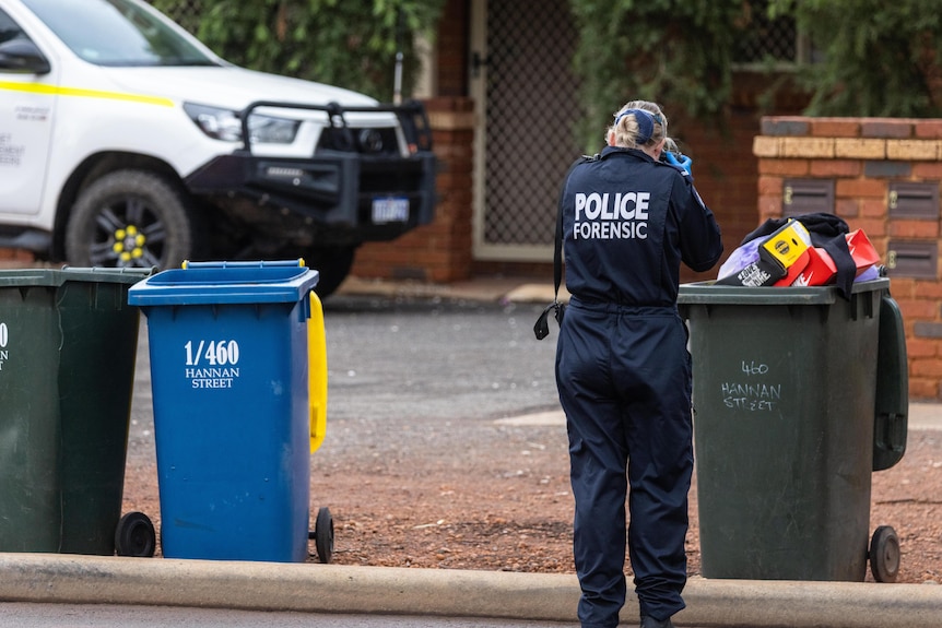 A police forensics officer photographing a crime scene.