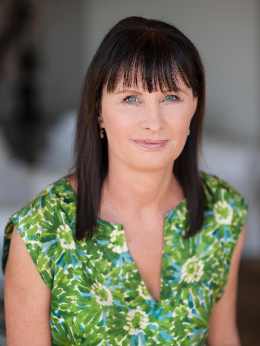 Catharine Lumby with brown hair and blue eyes, wearing a green and white outfit