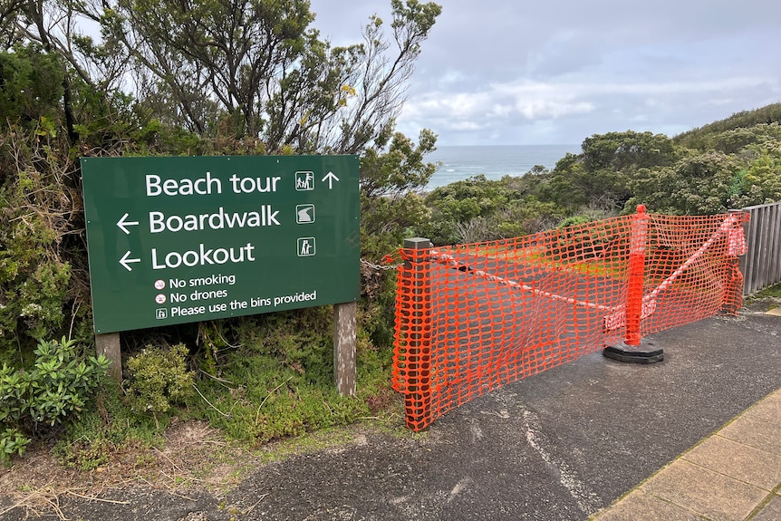 A directional sign showing the different tours, with access to beach tours blocked off by safety bollards and bunting.