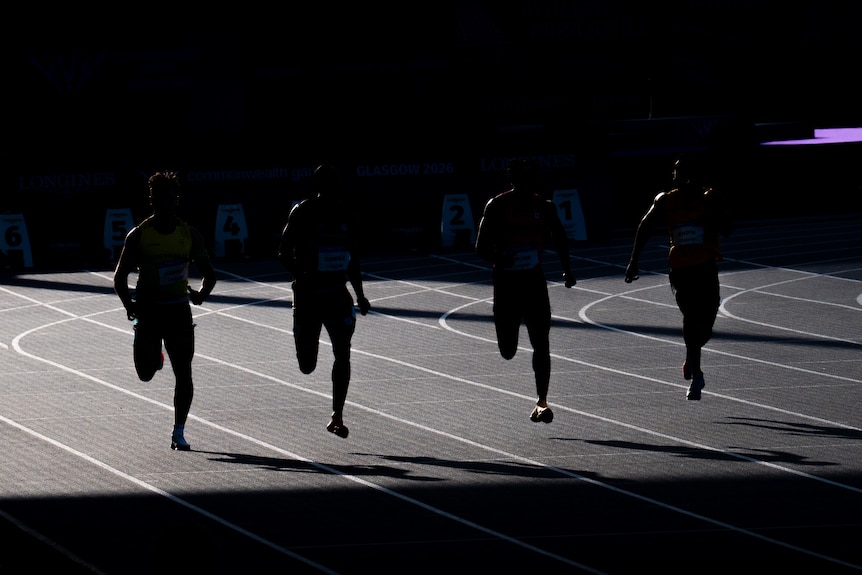 Runners silhouetted at Scotstoun Stadium during the 2026 Glasgow Commonwealth Games.