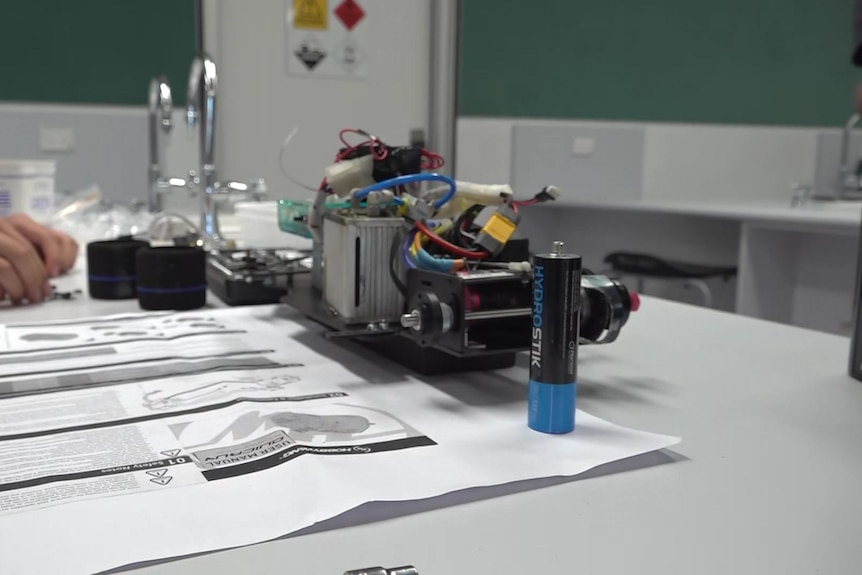 A stripped-down car behind a hydrogen fuel cell stick