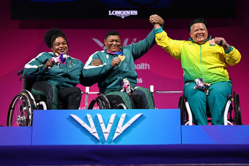 Powerlifters Rita Ferdinand, Folashade Oluwafemiayo and Hani Watson celebrate on the Glasgow Commonwealth Games podium.