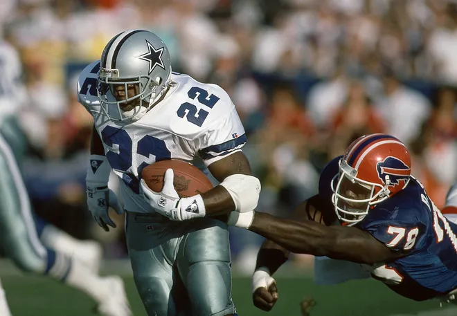 Jan 31, 1993; Pasadena, CA, USA; FILE PHOTO; Dallas Cowboys running back Emmitt Smith (22) carries the ball during Super Bowl XXVII past Buffalo Bills defensive end Bruce Smith (78) at the Rose Bowl. Smith rushed for 108 yards on 22 carries and 1 touchdown as the Cowboys defeated the Bills 52-17. Mandatory Credit: RVR Photos-USA TODAY Sports