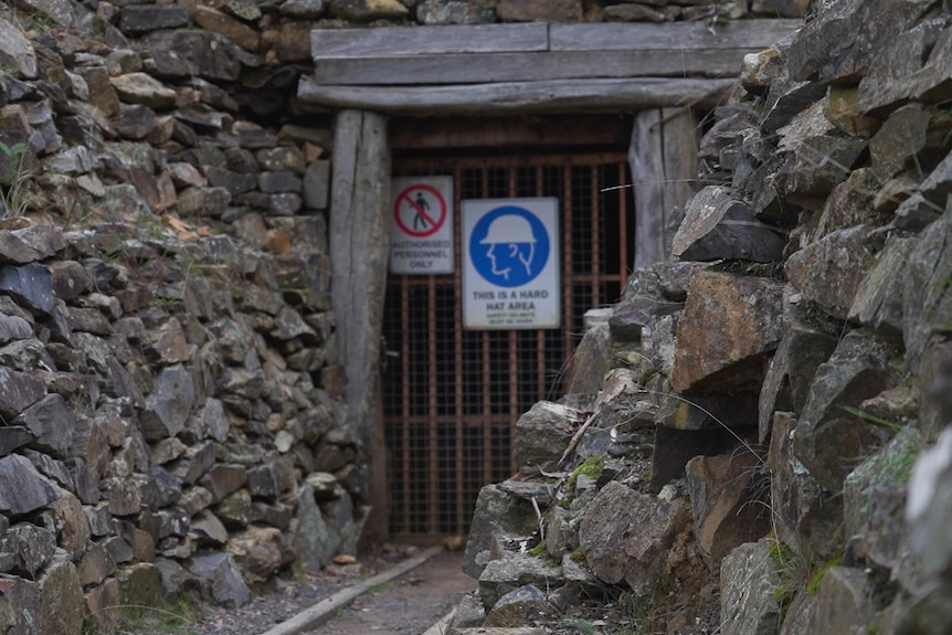 An entrance to an old gold mine with rocks as the gateway.