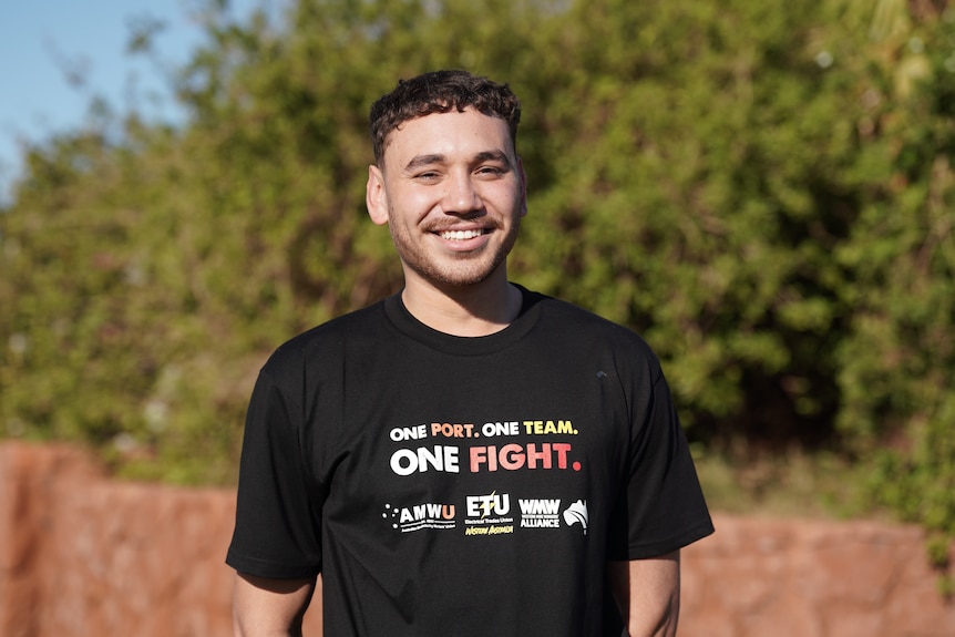 A man in a union t-shirt stands in front of the camera.