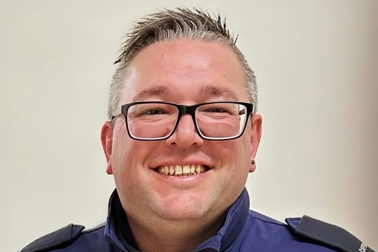 A photo of a CFA captain, wearing a blue CFA uniform and glasses