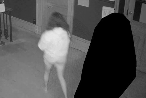 A woman and a person whose identity in a hallway.