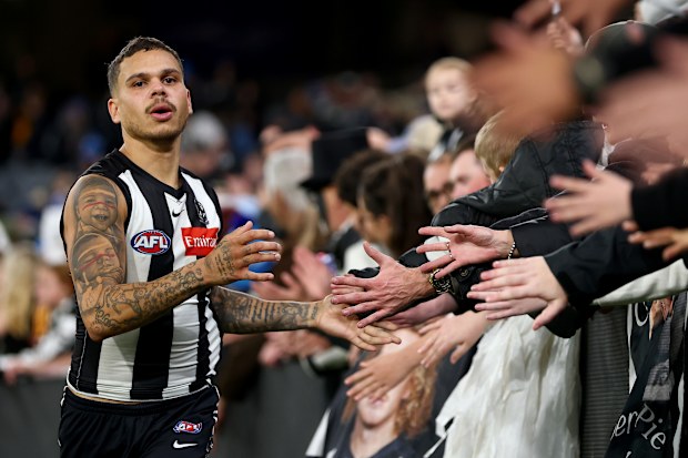 Bobby Hill of the Magpies high-fives fans.