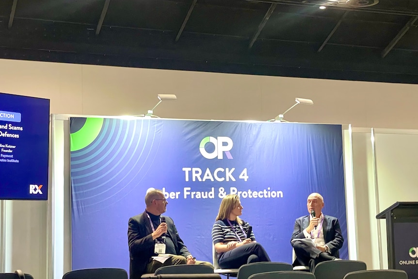 Nina sits on stage and talk with two other men as a panel about chargebacks.