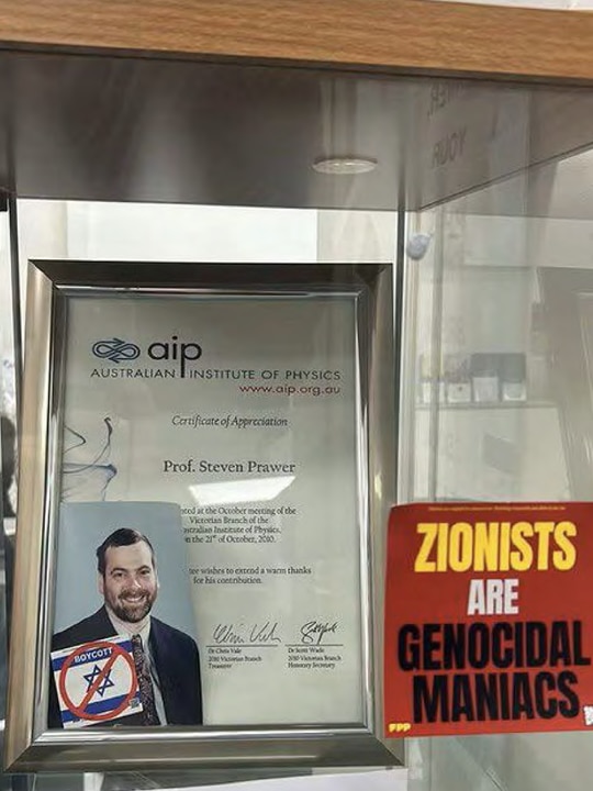 A framed certificate of appreciation has a boycott sticker on it and a sign saying "zionists are genocidal maniacs".