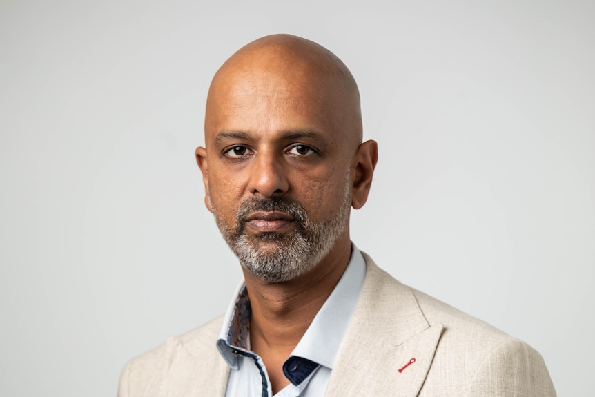 man looking serious in a cream suit