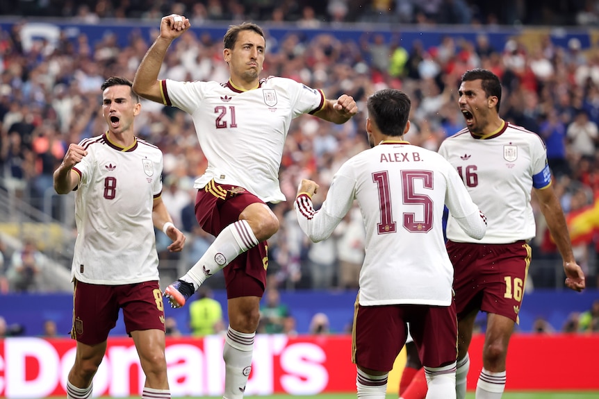 Mikel Oyarzabal celebrates his goal by leaping into the air alongside teammates