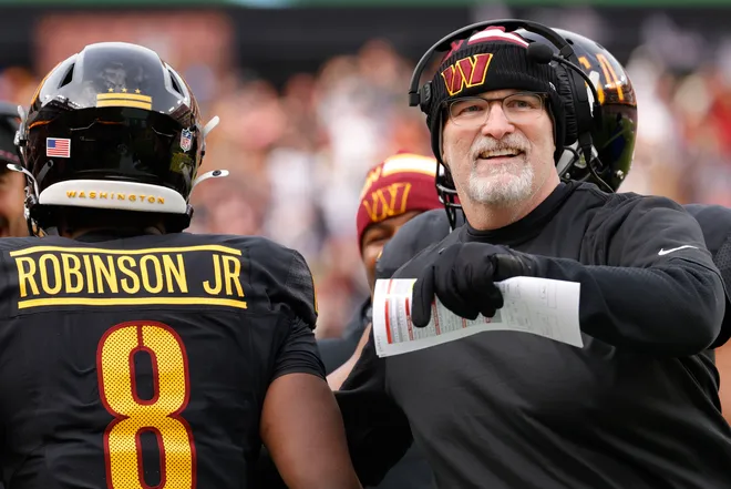 Dec 1, 2024; Landover, Maryland, USA; Washington Commanders head coach Dan Quinn (right) celebrates with Commanders running back Brian Robinson Jr. (8) after scoring a touchdown against the Tennessee Titans during the first half at Northwest Stadium. Mandatory Credit: Amber Searls-Imagn Images