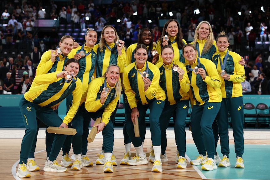 The Opals players pose with their Olympic bronze medals in Paris