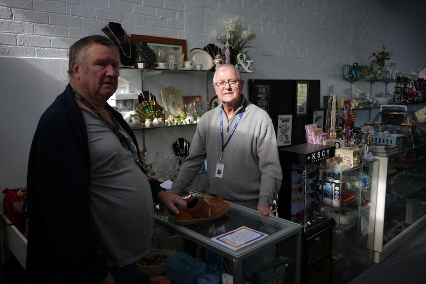 two men at counter with sun on one man's face