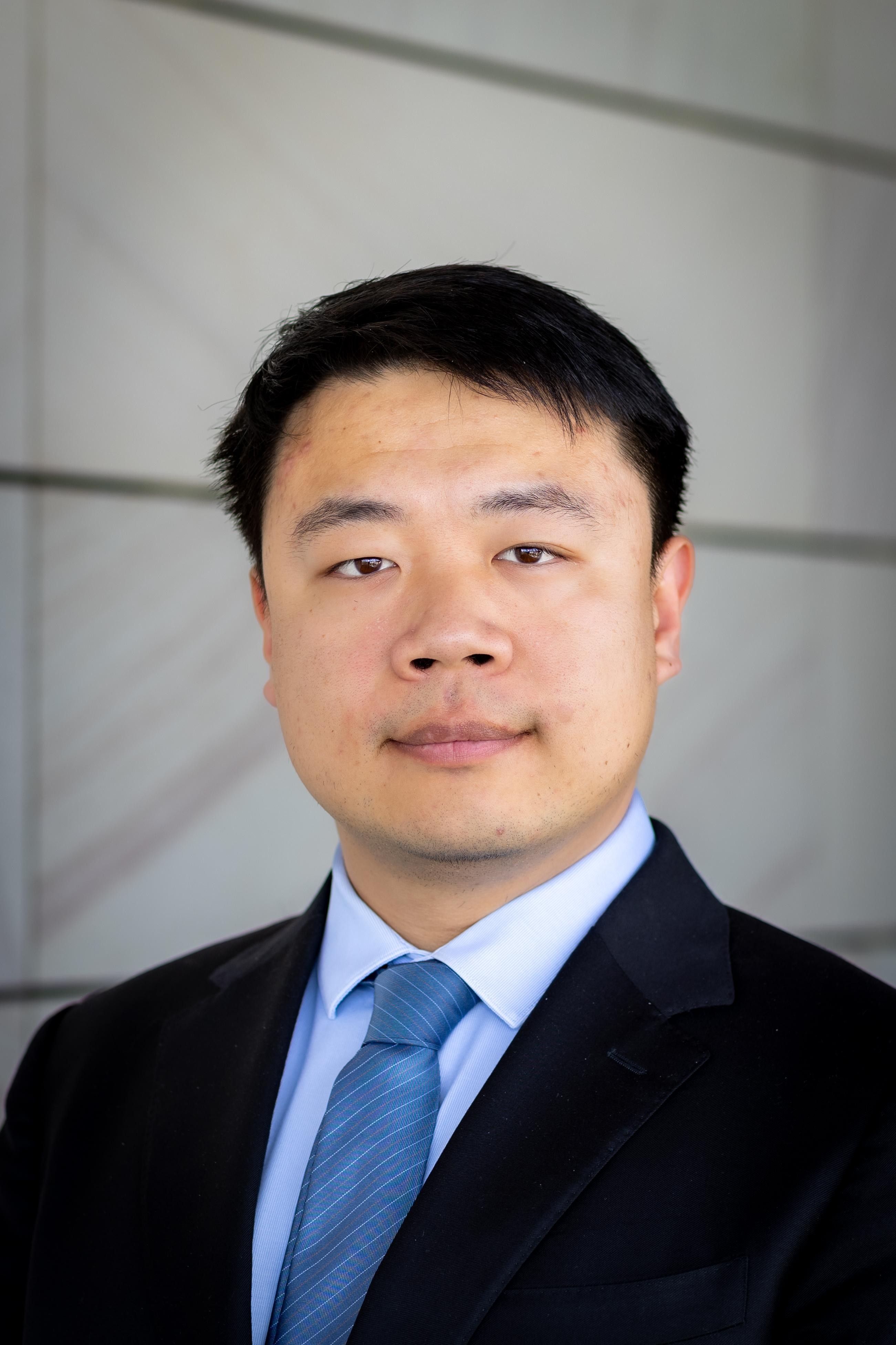 A Chinese man, smiling.