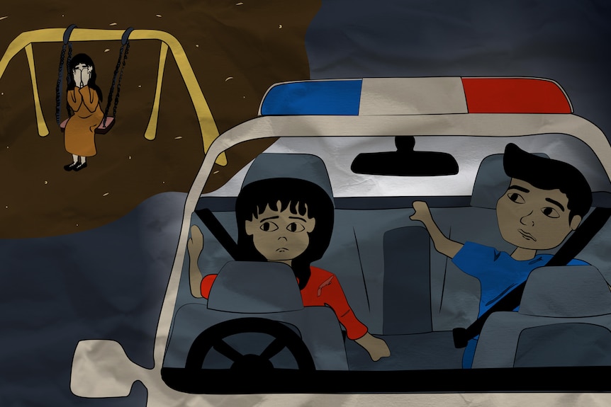 Children sit in the back of a police car