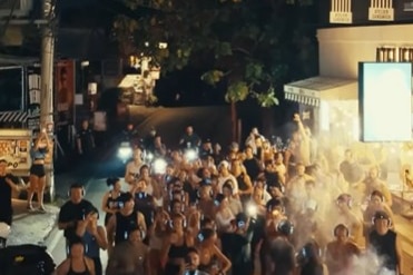 a group of people running in the dark taken from a slight aerial view.