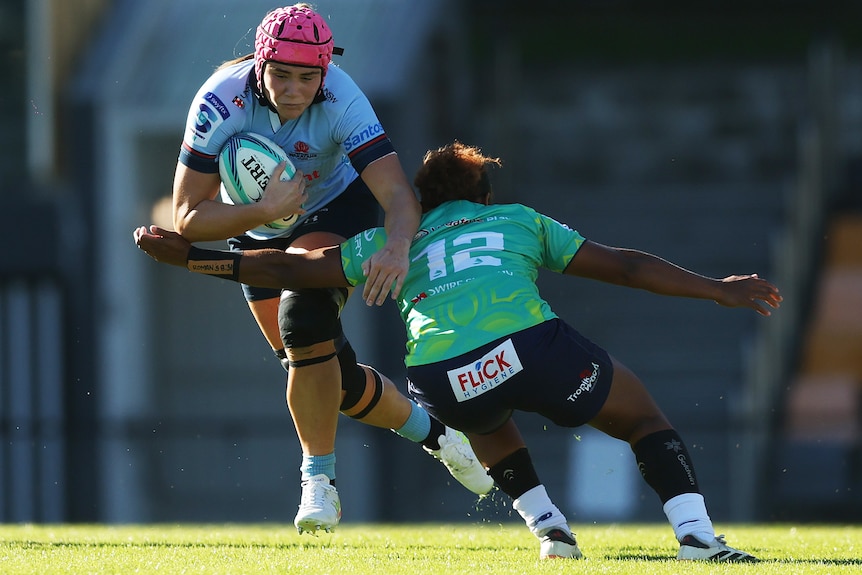 Piper Duck runs the ball for the Waratahs at the Drua defence in 2026.