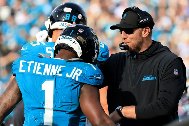 JACKSONVILLE, FLORIDA - JANUARY 11: Head coach Liam Coen of the Jacksonville Jaguars congratulates Travis Etienne Jr. #1 after a touchdown during the fourth quarter against the Buffalo Bills in the AFC Wild Card Playoff game at EverBank Stadium on January 11, 2026 in Jacksonville, Florida. (Photo by Mike Carlson/Getty Images)