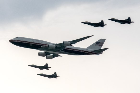Military aircraft flank Air Force One in a flypast over the National Mall.