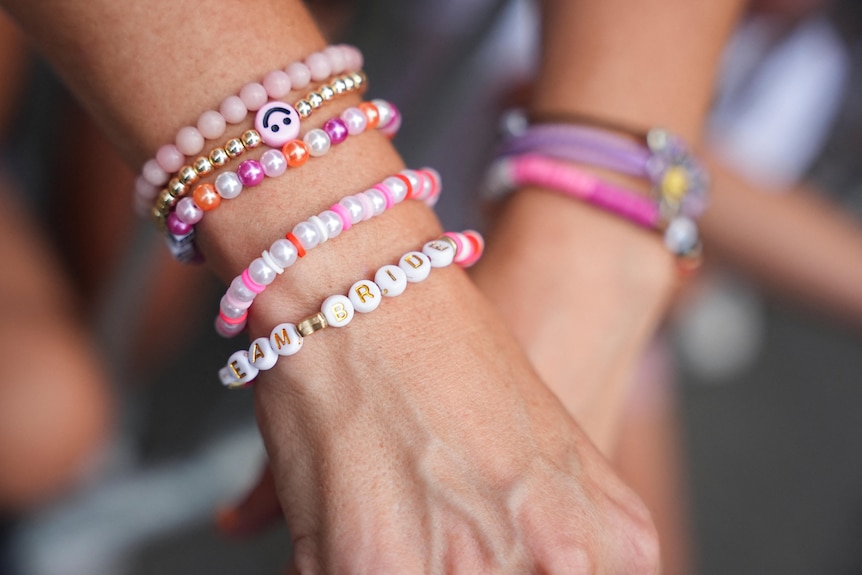 A Taylor Swift fan wears a friendship bracelet with "bride" on it.