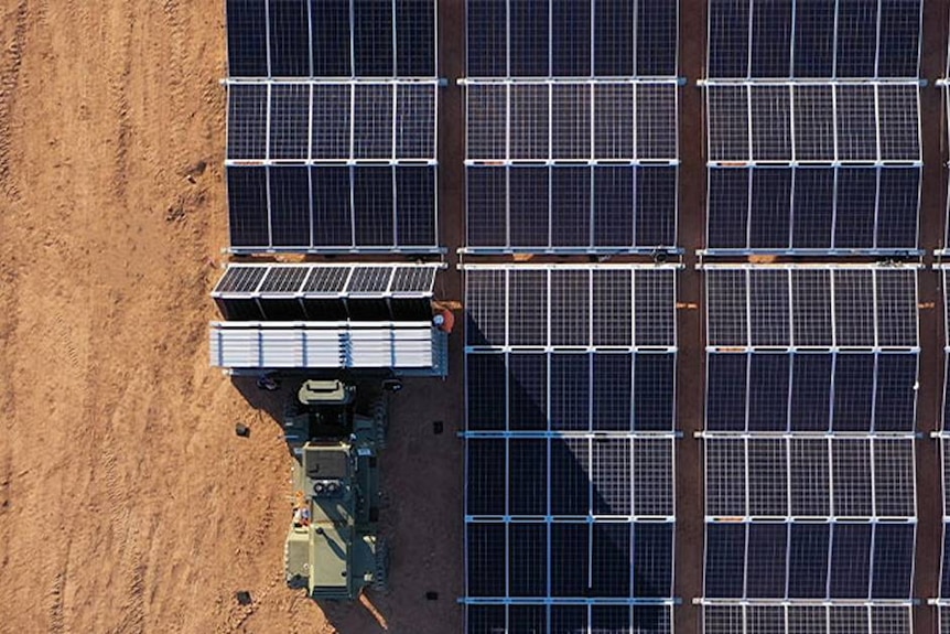 A truck pushes foldable solar arrays
