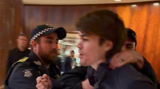 A screenshot of Neo-Nazi associate Hugo Lennon being ejected by police from the Melbourne hotel where Indian Prime Minister Narendra Modi was staying overnight.