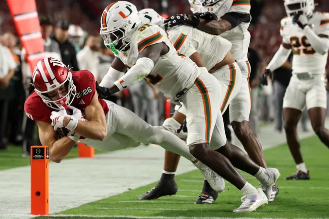 Jan 19, 2026; Miami Gardens, FL, USA; Indiana Hoosiers wide receiver Charlie Becker (80) makes a catch against MMiami Hurricanes linebacker Wesley Bissainthe (31) in the first half during the College Football Playoff National Championship game at Hard Rock Stadium. Mandatory Credit: Nathan Ray Seebeck-Imagn Images